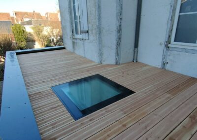 Extension en ossature bois avec terrasse et fenêtre praticable